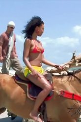 Negra montando a caballo en la playa termina en doble penetración